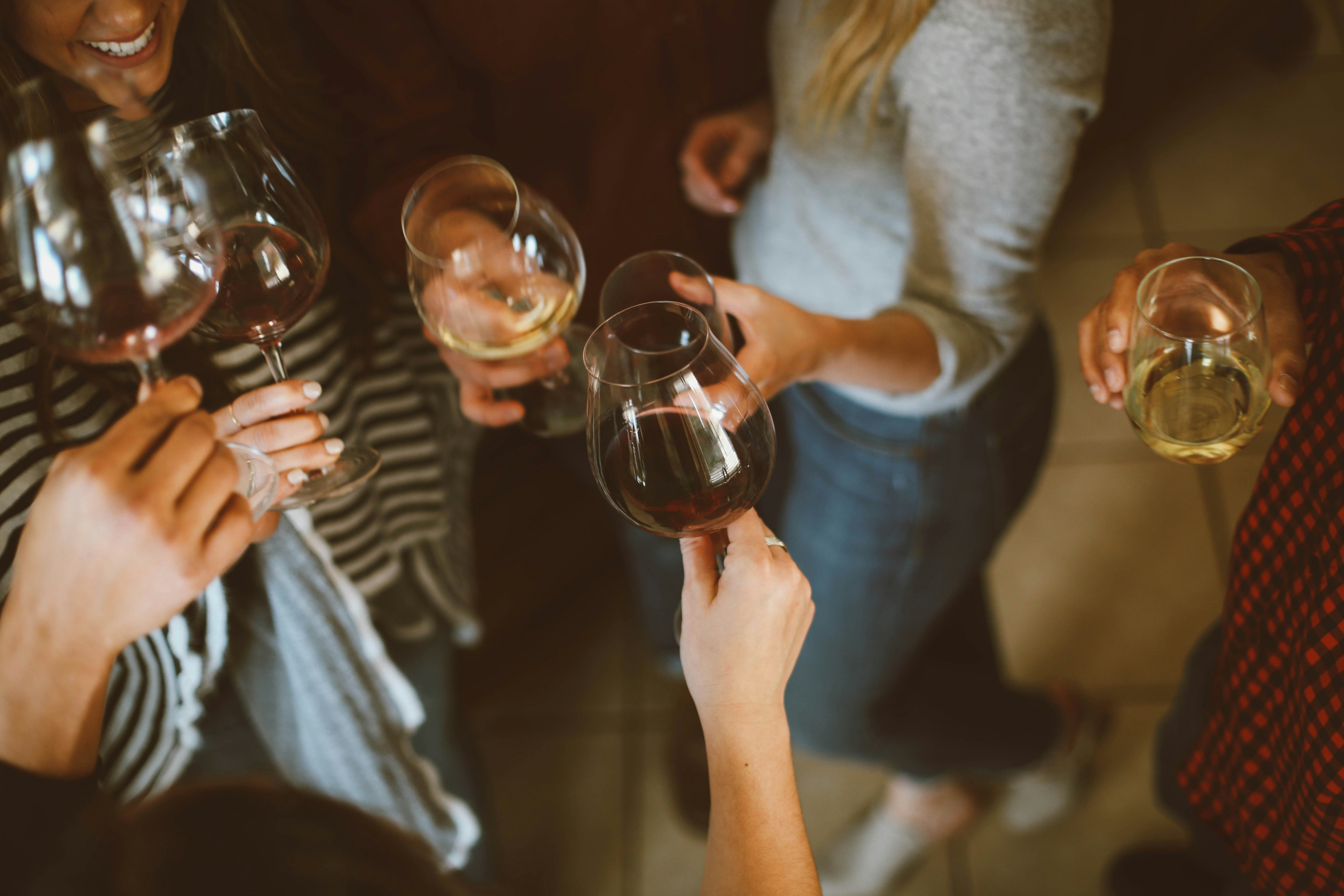 A group of people putting their wine glasses together