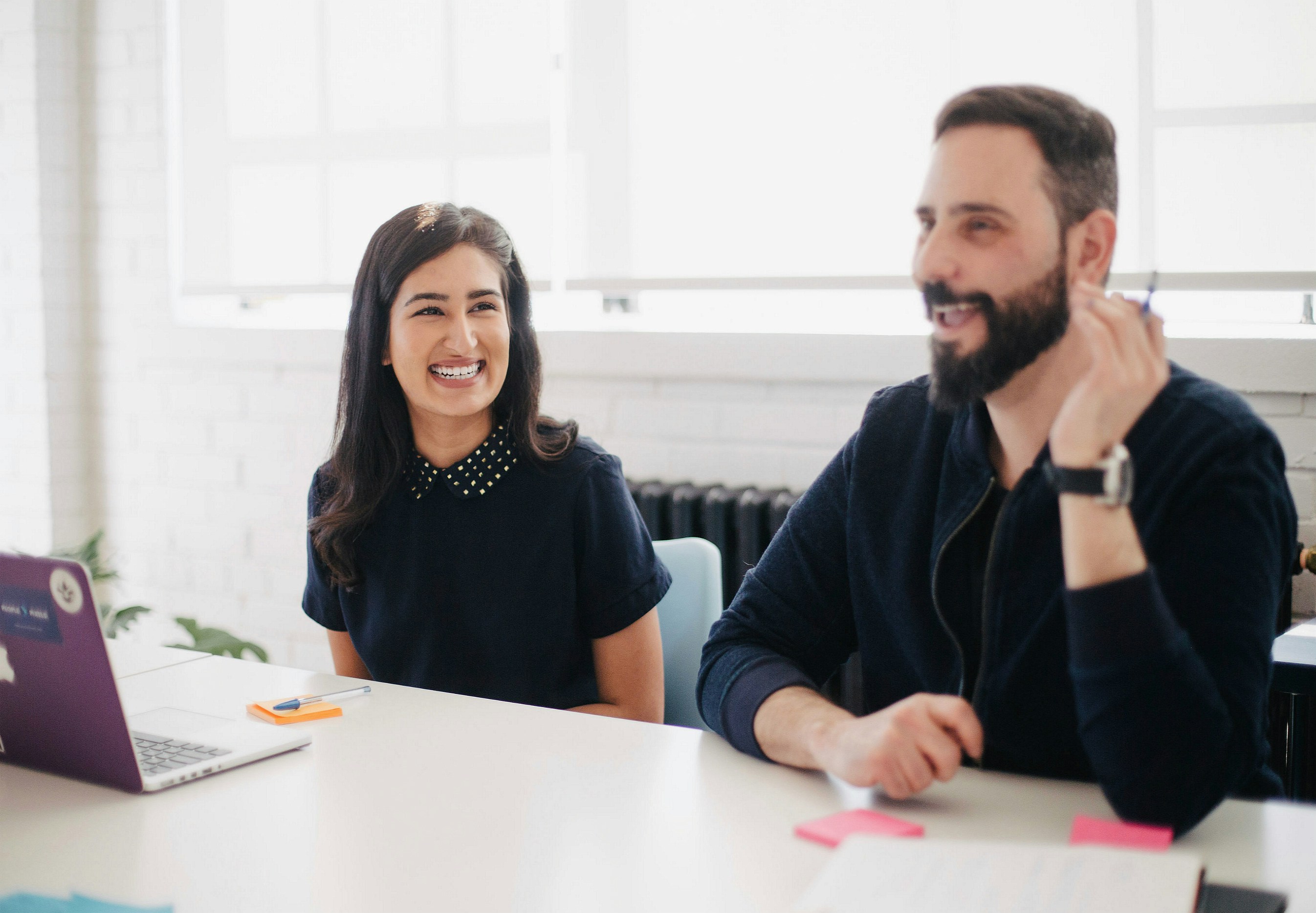 Two people in a meeting smiling