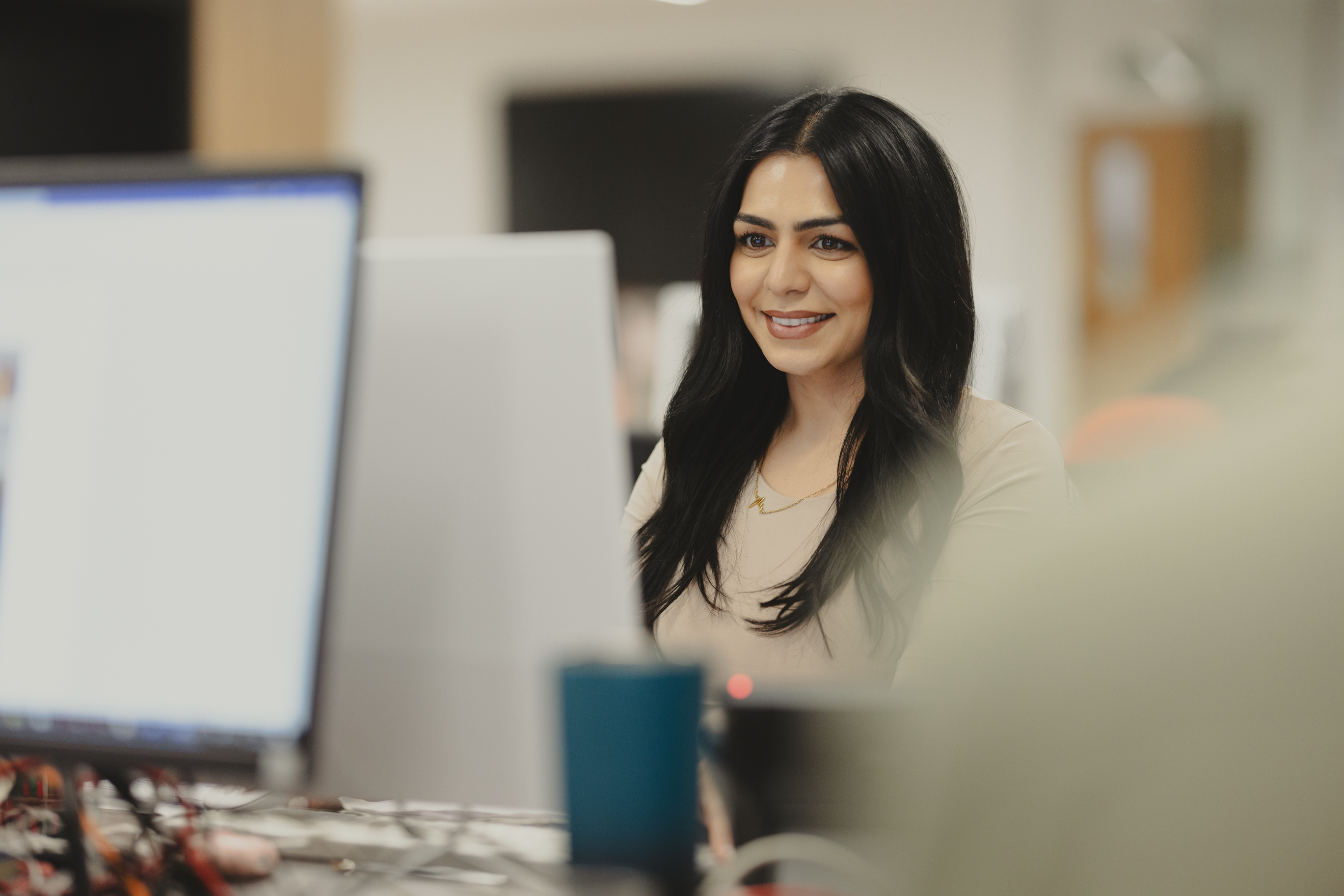 Woman in office smiling at computer