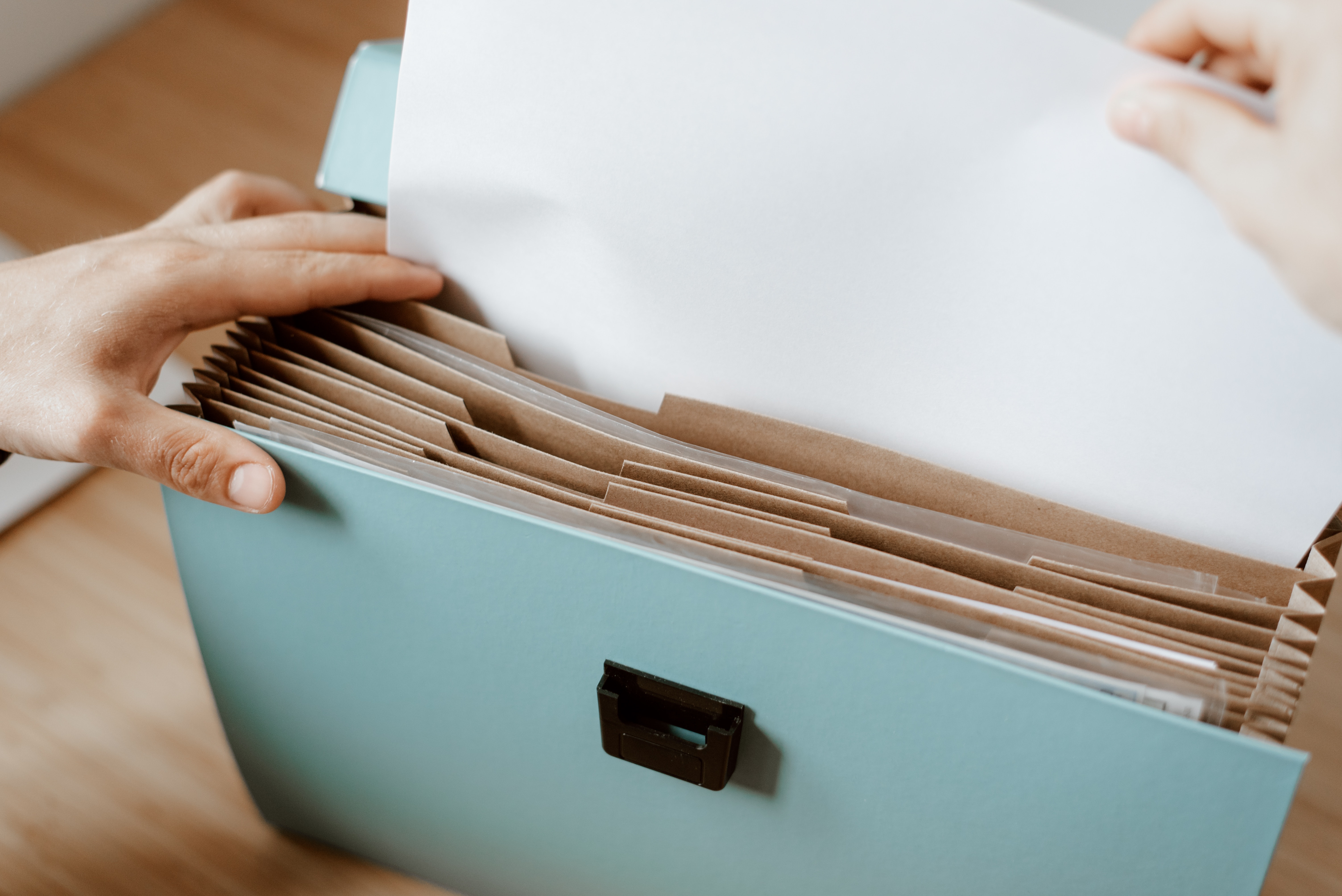 Close up of hands looking through papers in a folder