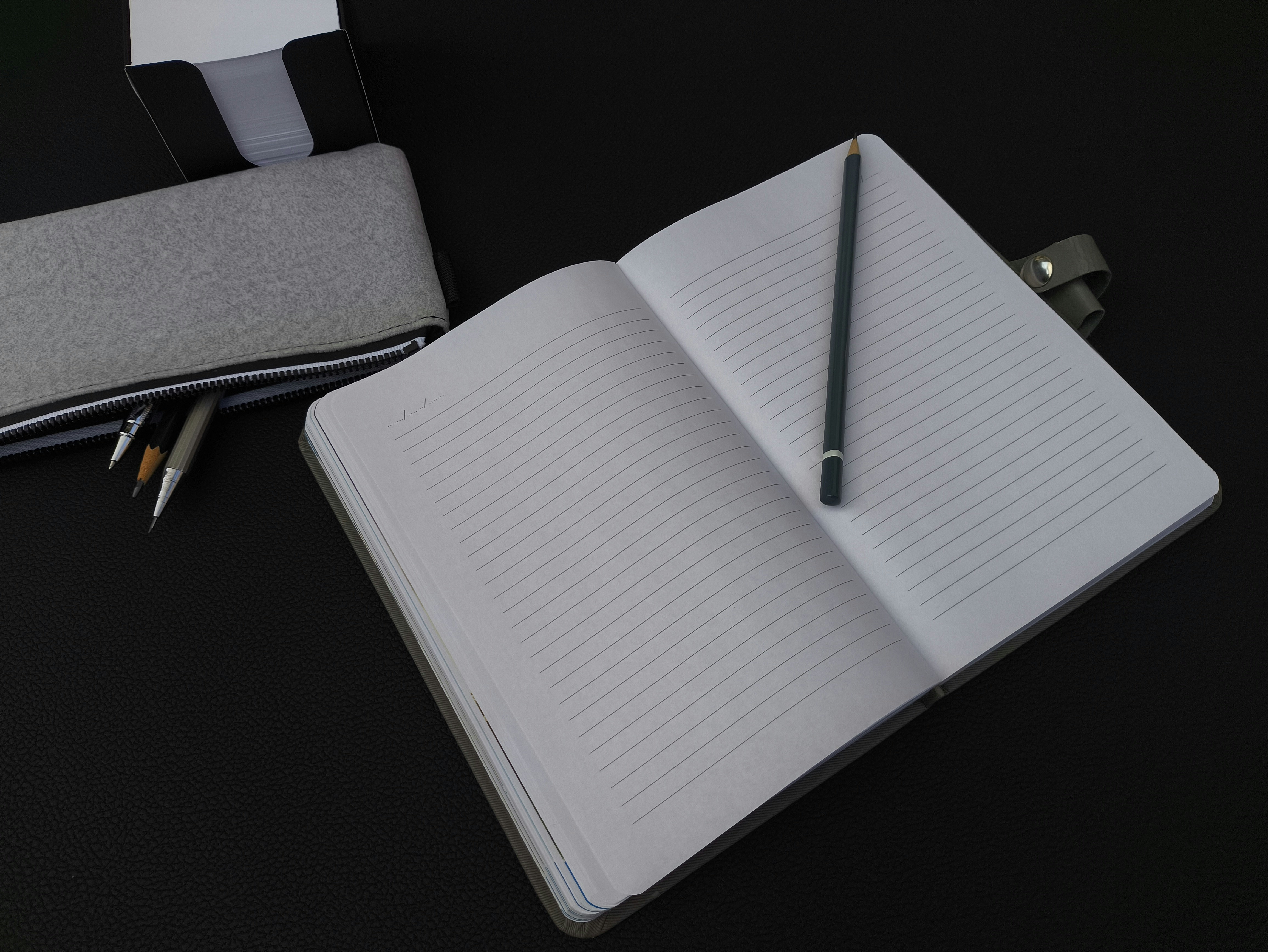 Blank notepad with pencil on top