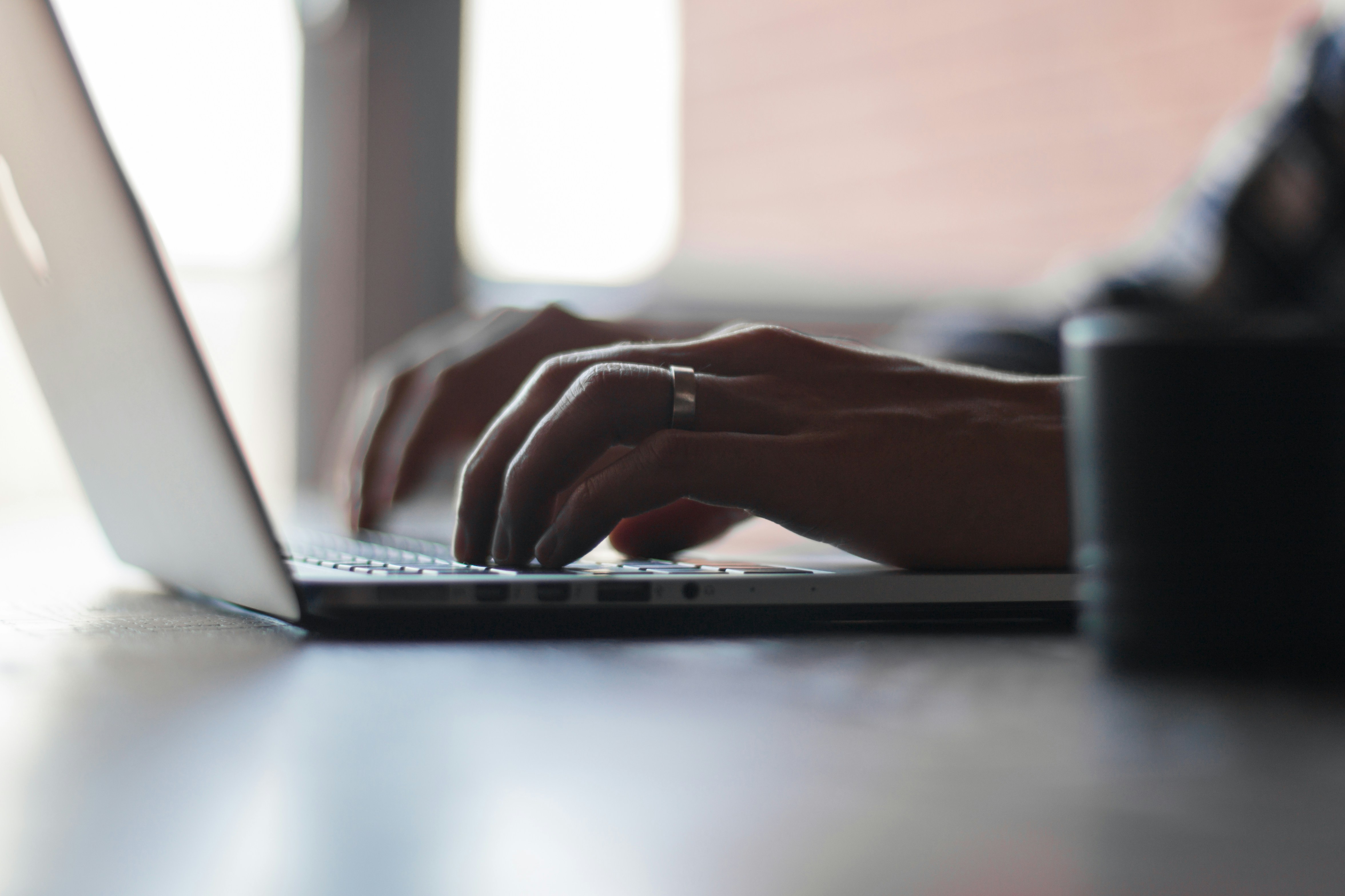 Close up on hands typing on a laptop