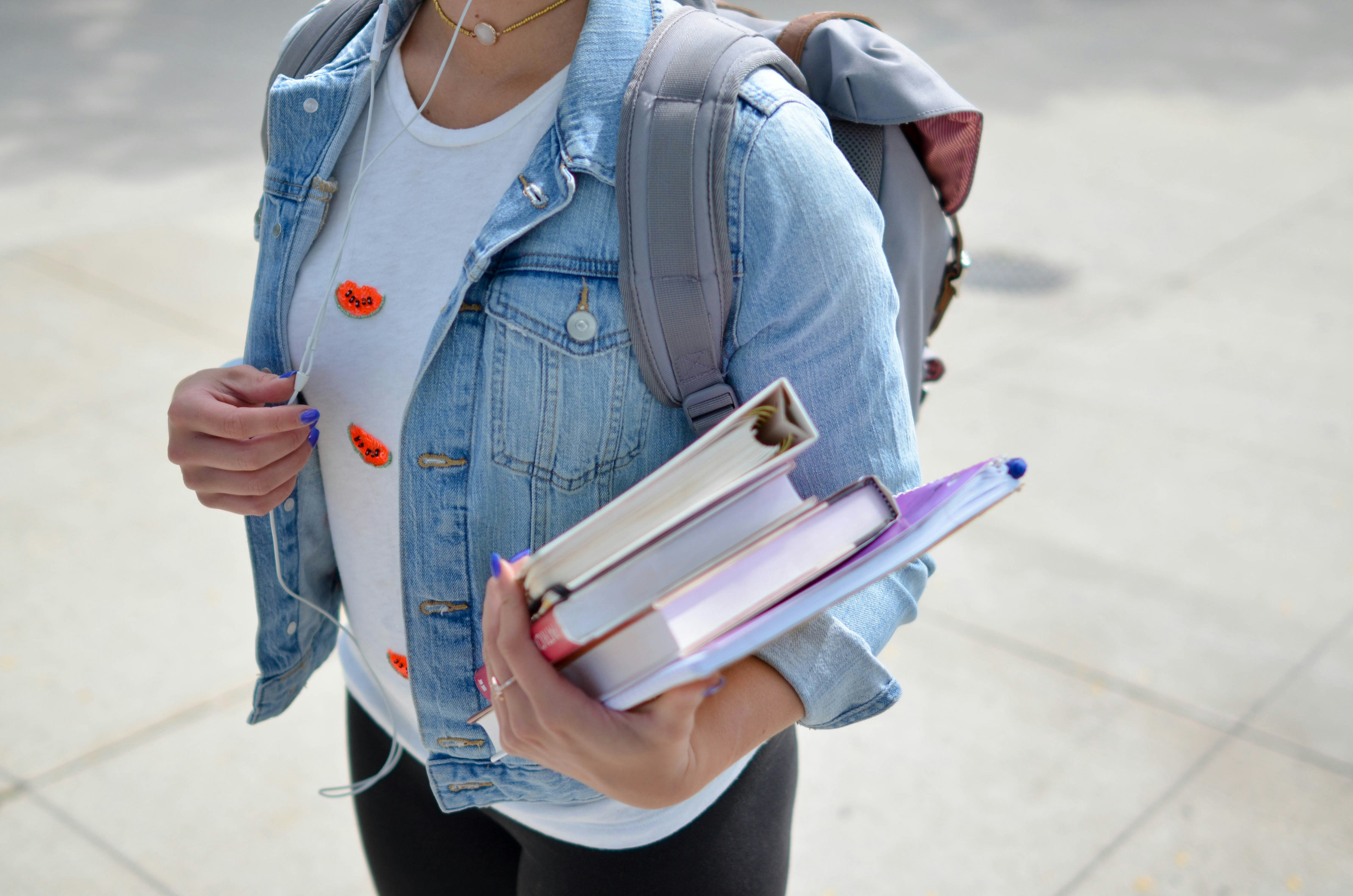 Female with backpack holding text books