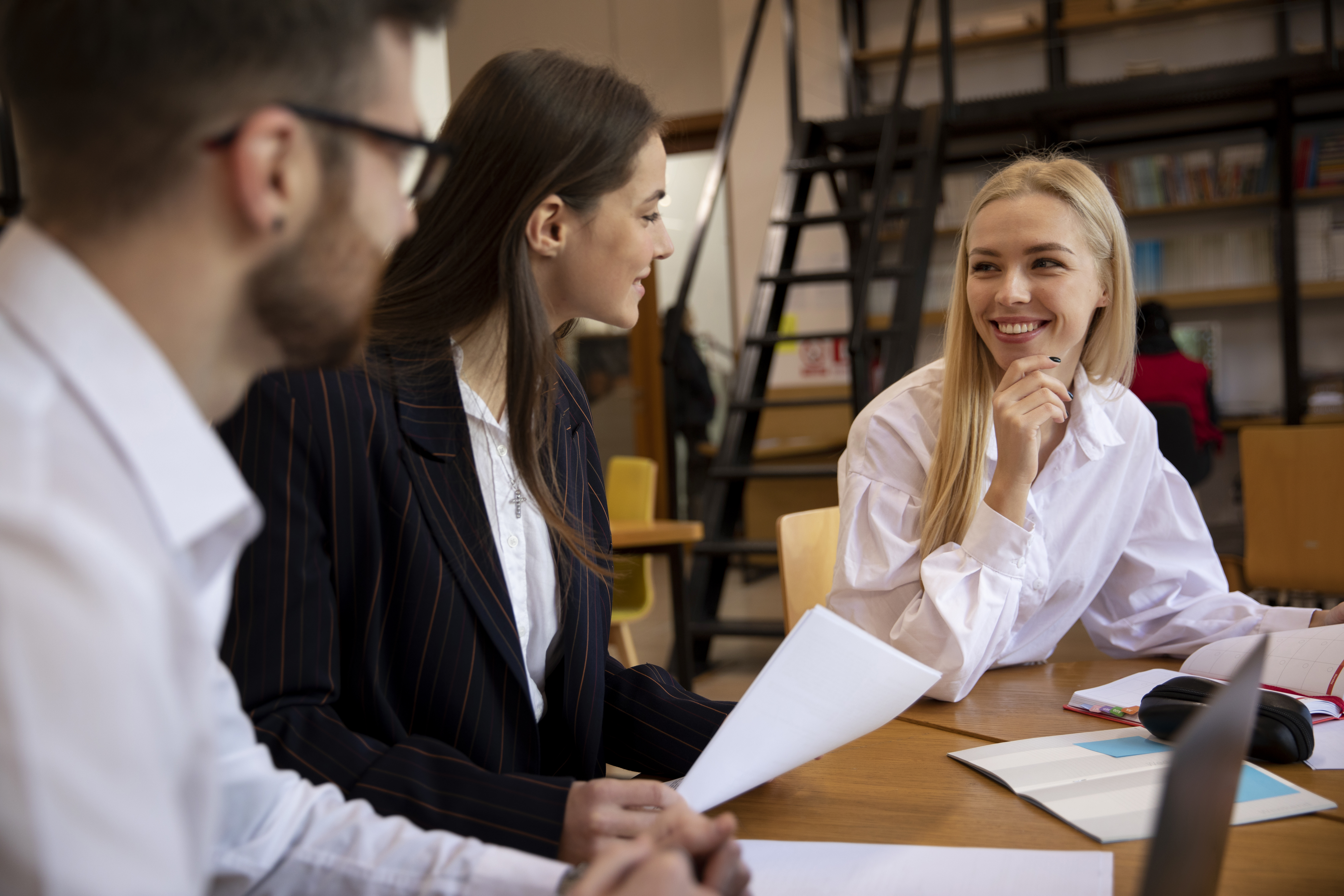 Three people sat down in an office setting having a conversation.