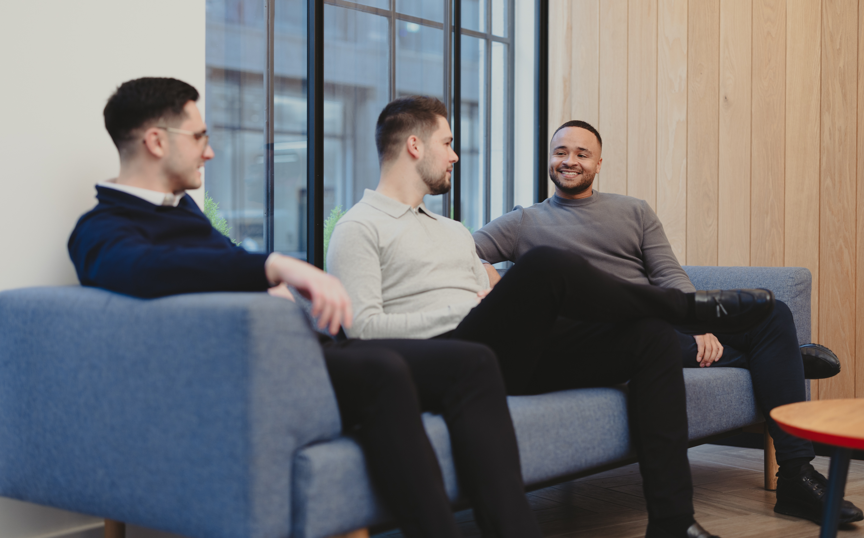 Three men having a conversation in office