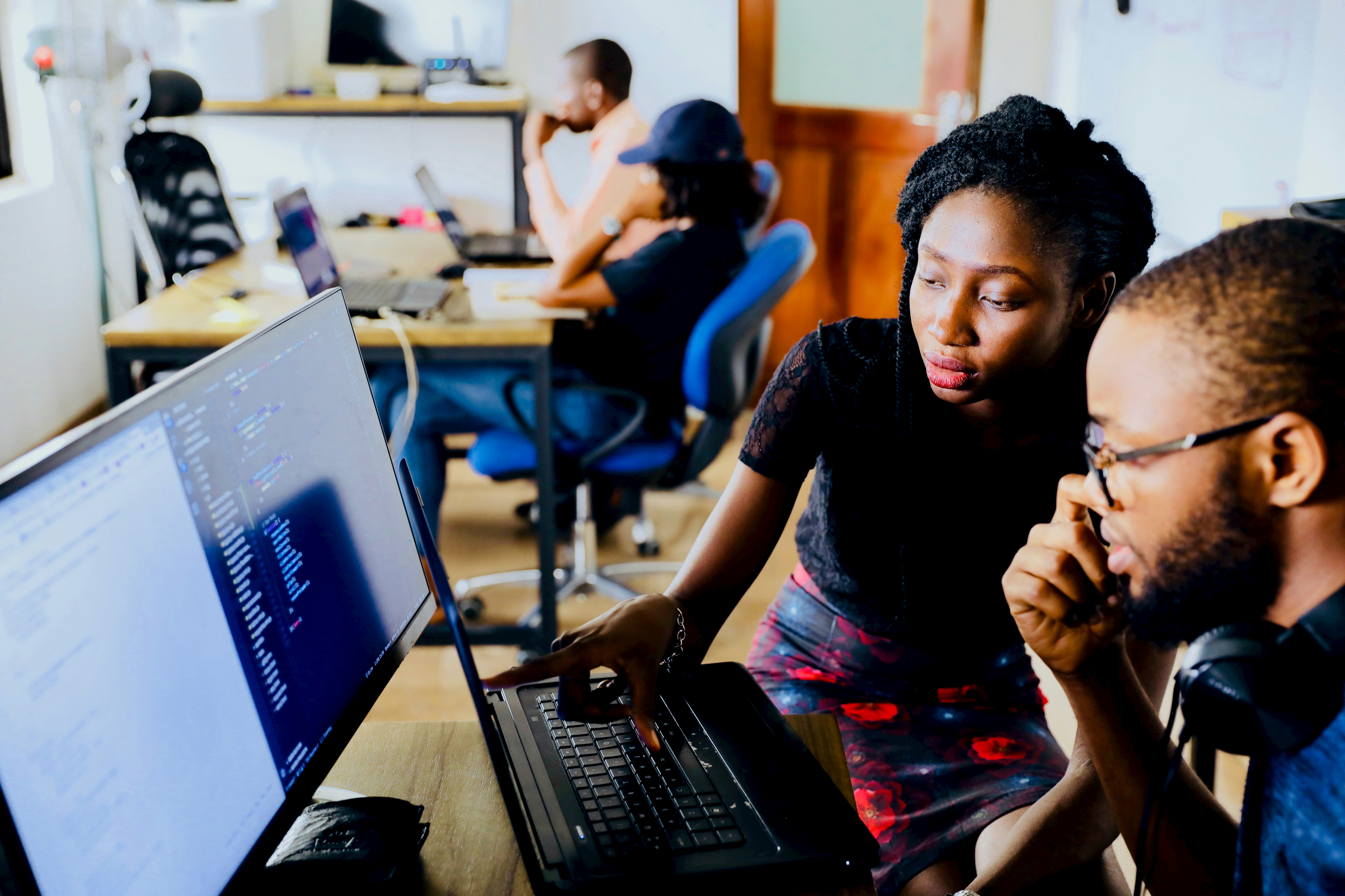 Woman showing a man something on a computer screen in an office setting